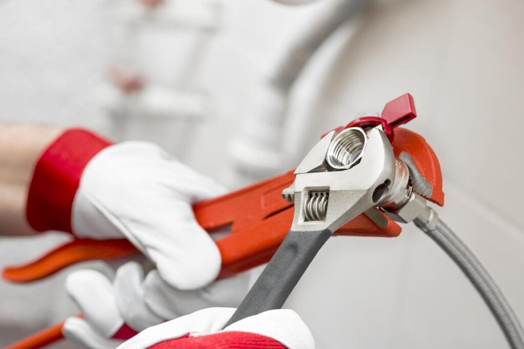 Plumber holding pipe wrenches for an emergency repair in Salinas