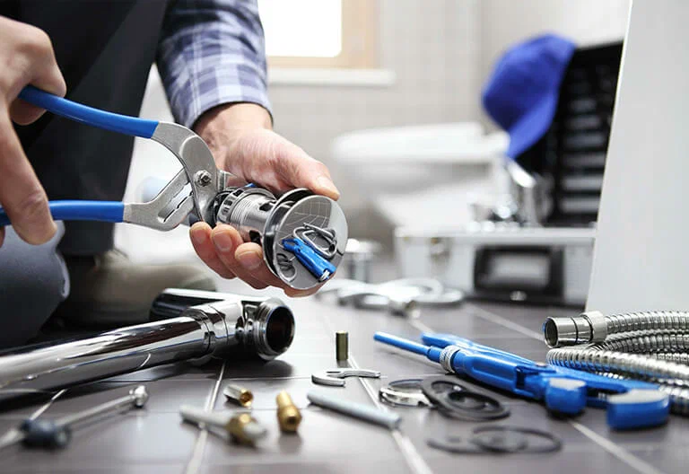 Technician repairing a plumbing fixture with professional tools in Salinas