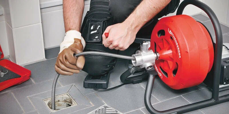 Plumber using a drain-cleaning machine in Salinas