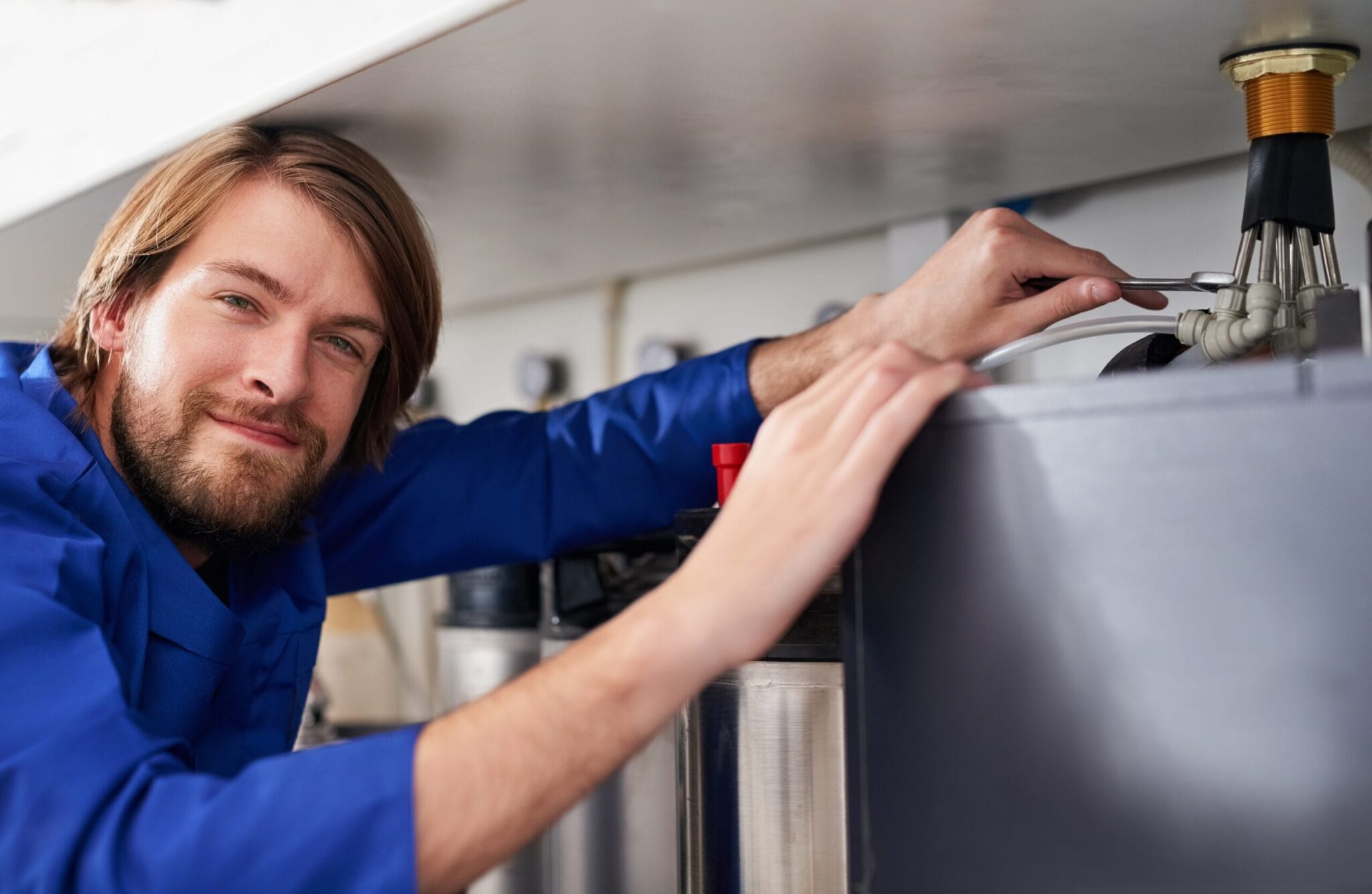 Technician servicing a residential water heater tank in Salinas